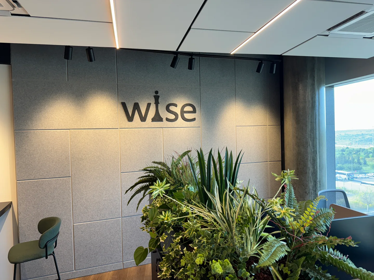 The Wise logo wall beside greenery and natural light